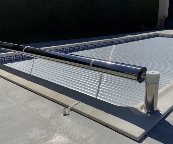 Volet de piscine hors sol avec structure en inox 316L, en position fermée sur le bassin, en plein jour à Marseille.