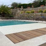 Volet de piscine immergé Aqualiss en train de se dérouler sur le bassin à Palavas en journée, intégration discrète et élégante