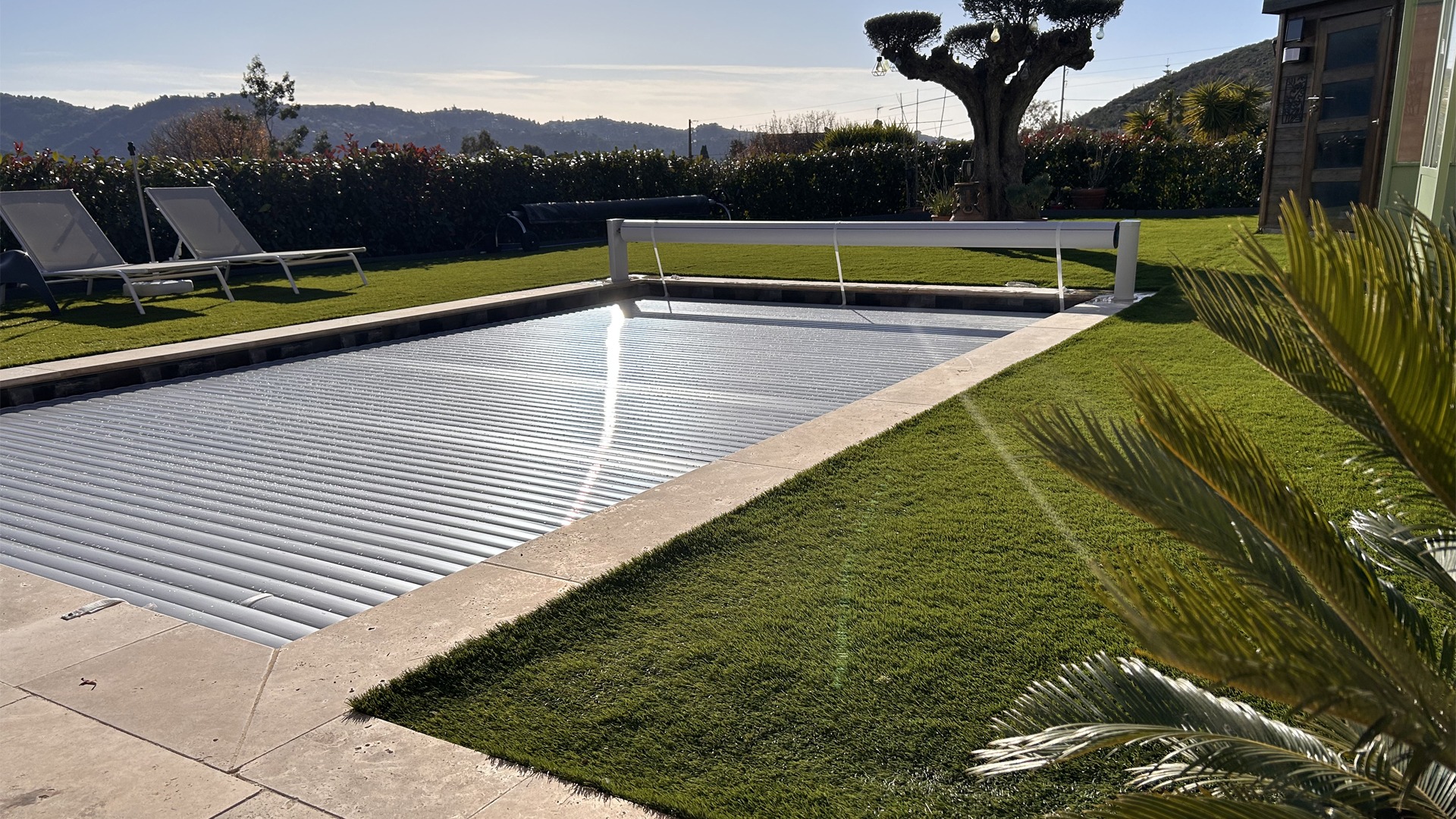 Volet de piscine hors sol sur mesure couleur vanille, fermé sur la piscine, photographié en pleine journée à Nîmes.
